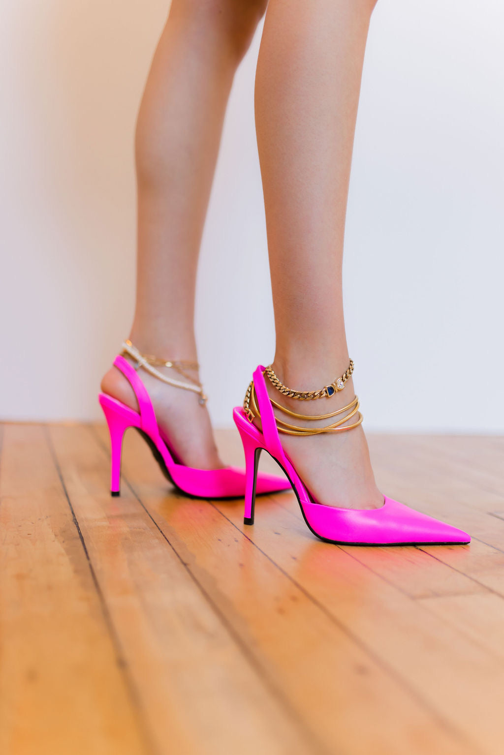 Bondeye Jewelry NYC jewelry brand model wearing pink heels and multiple gold anklets
