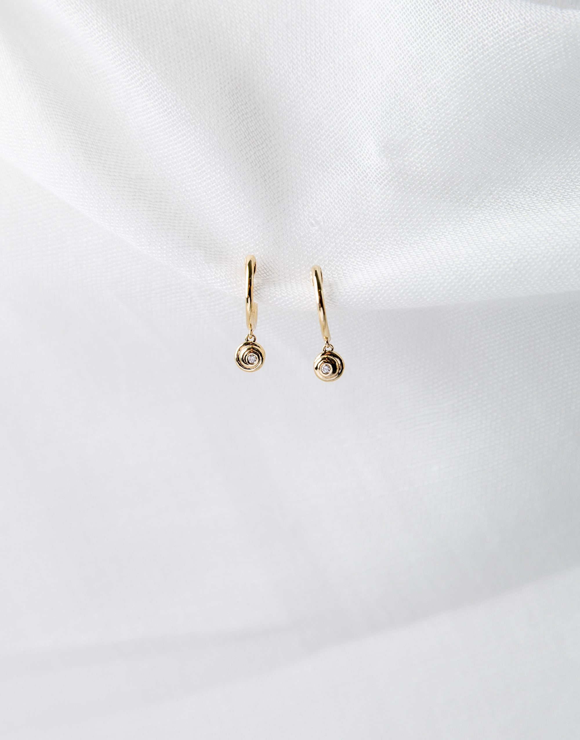 Lucy Huggies in 14K yellow gold with white diamond spiral design