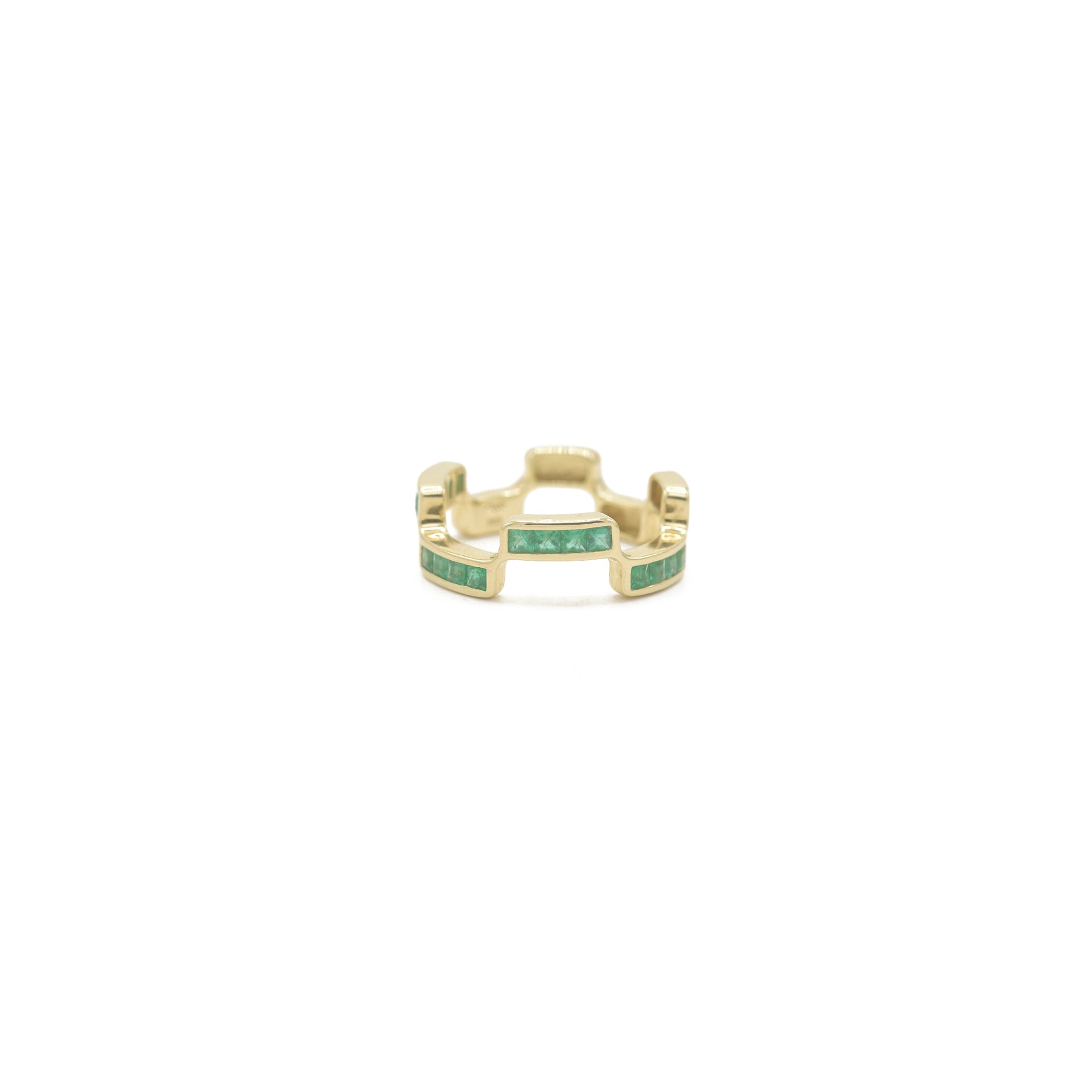 Puzzle Block Gold ring with emerald gemstones on a white background