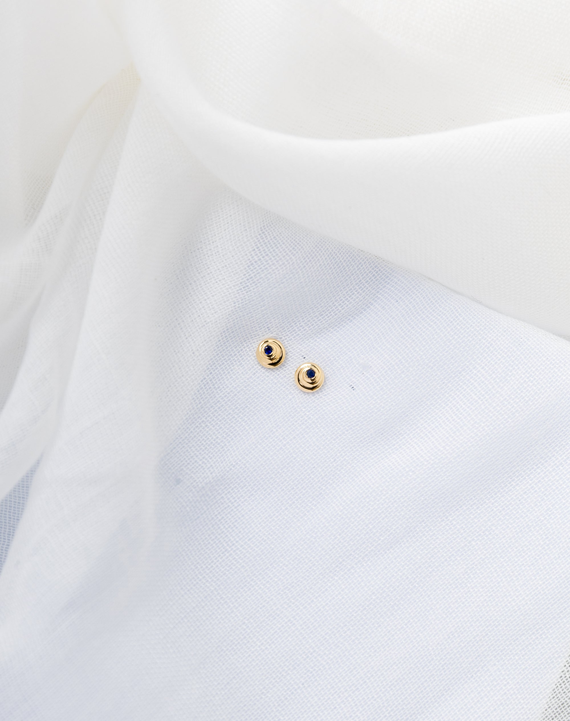 Cami Studs in 14K gold with spiral shape and deep blue sapphires