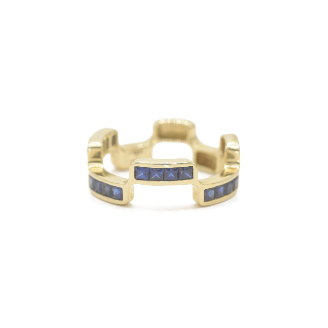 Puzzle Block Gold ring with blue sapphire gemstones on a white background