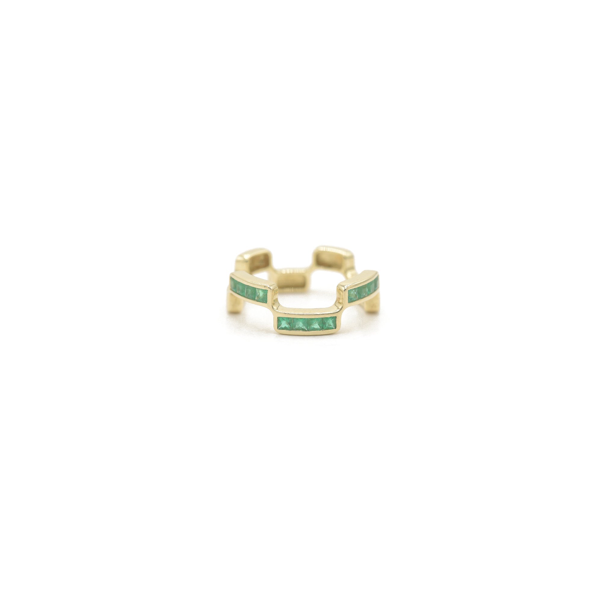 Puzzle Block Gold ring with emerald gemstones on a white background