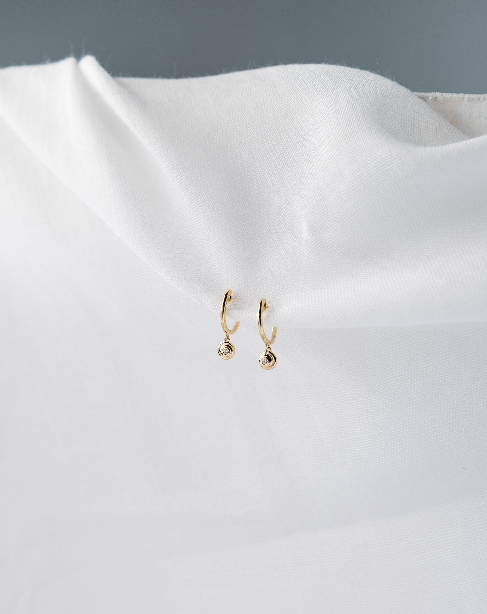 Lucy Huggies in 14K yellow gold with white diamond spiral design