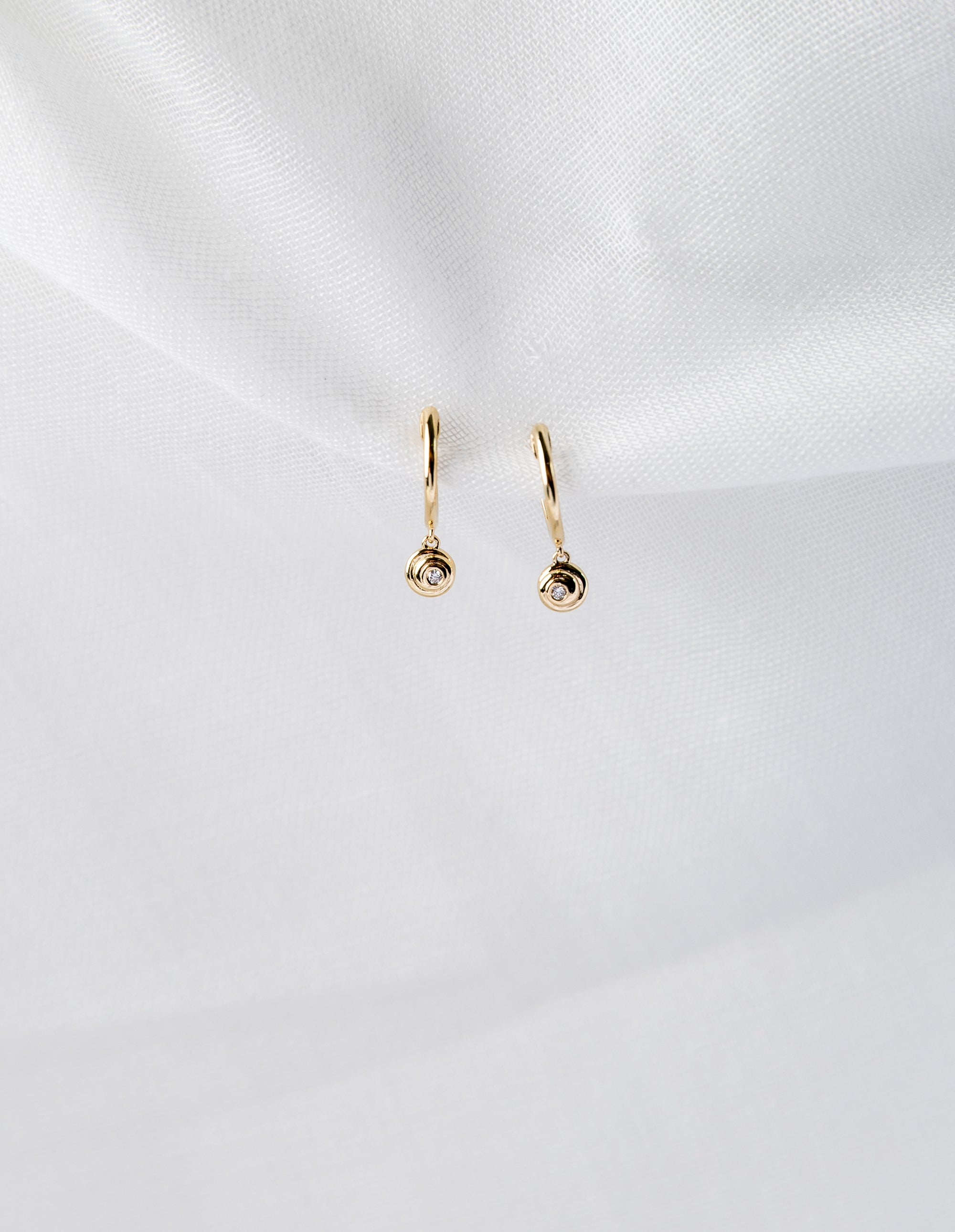 Lucy Huggies in 14K yellow gold with white diamond spiral design