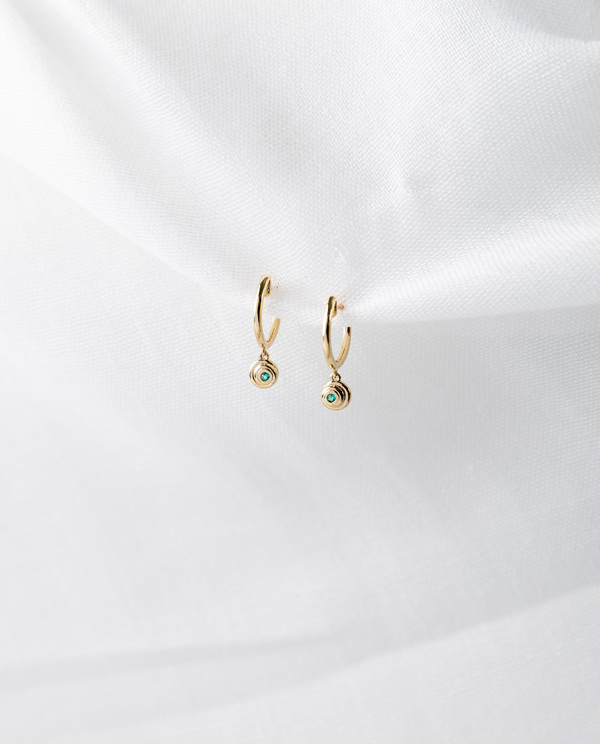 Lucy Huggies in 14K yellow gold with emeralds spiral design