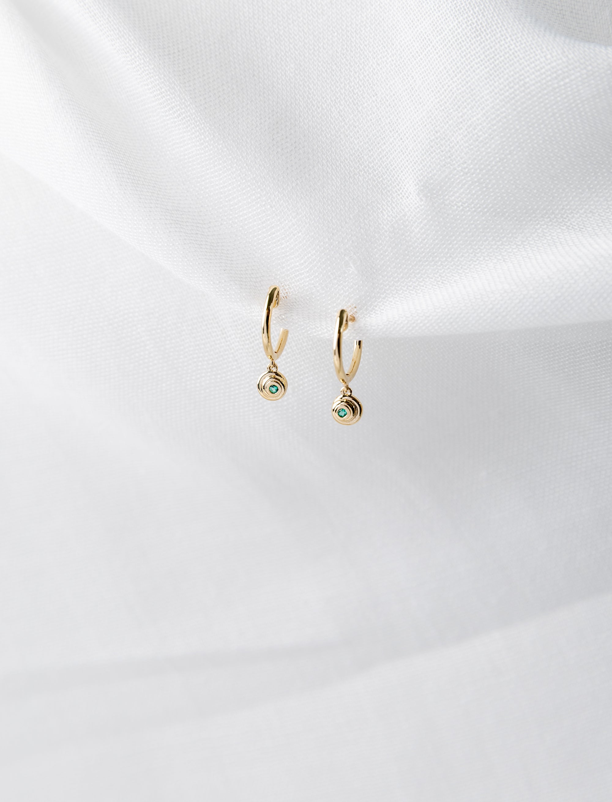 Lucy Huggies in 14K yellow gold with emeralds spiral design