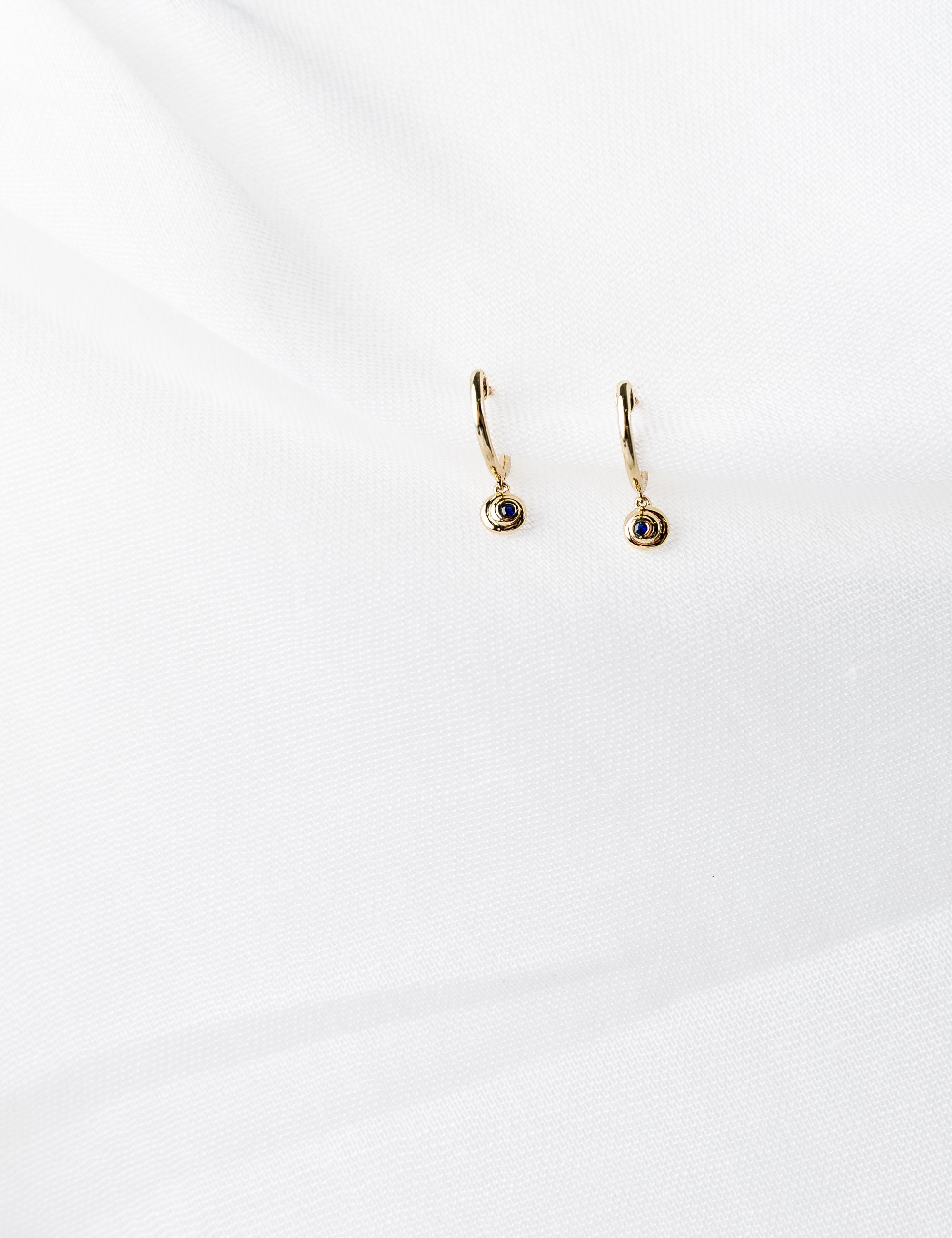 Lucy Huggies in 14K yellow gold with blue sapphires spiral design