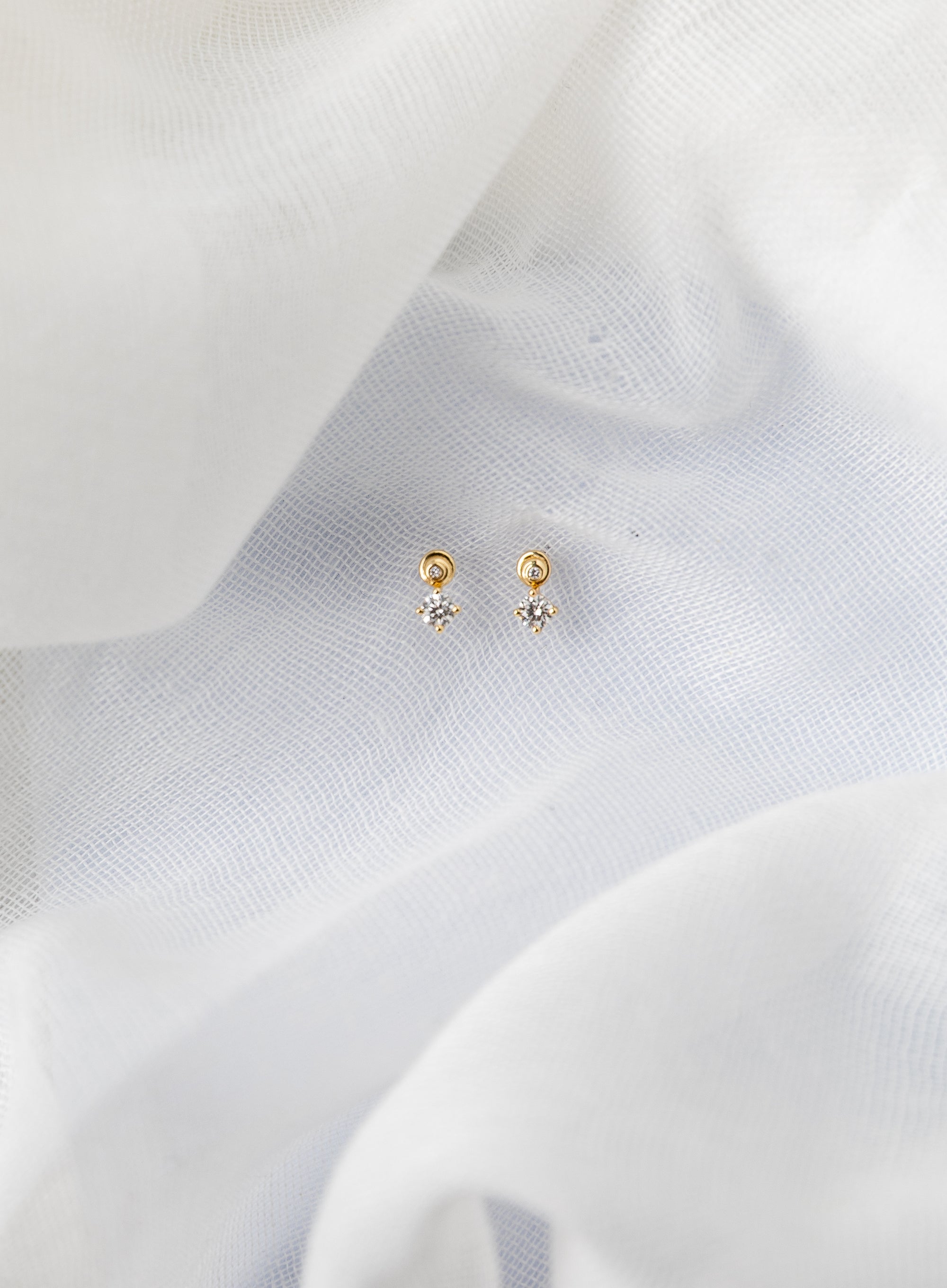 Spiral gold stud earrings with white diamonds